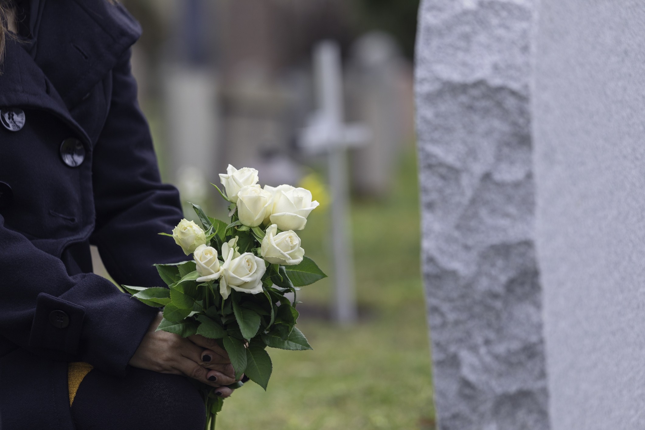 Woman leaving flowers at a grave